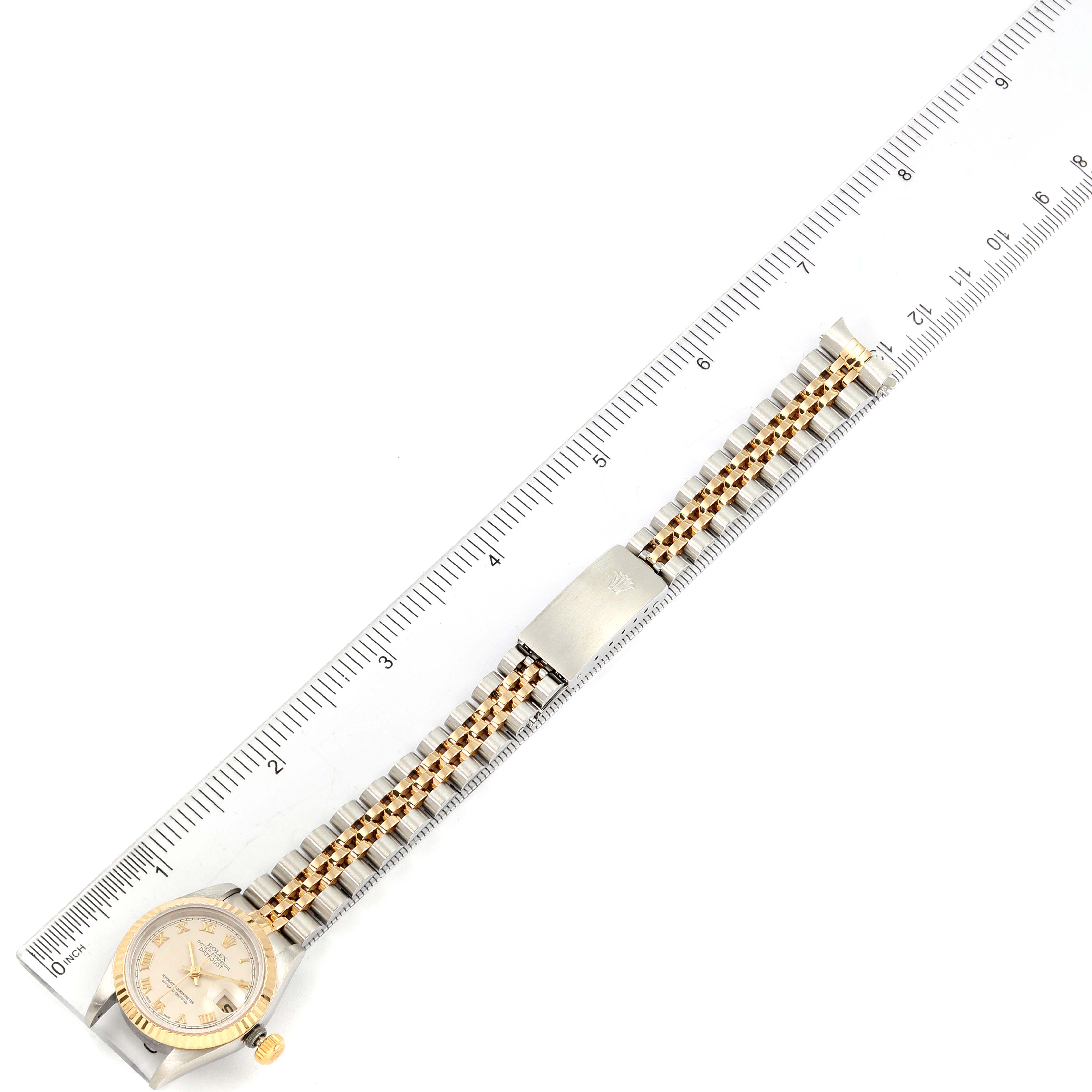 The image shows a Rolex Datejust 69173 Women's Steel and Gold (two tone) Beige Dial 69173 Women's Steel and Gold (two tone) Beige Dial watch laying flat, with its face, clasp, and strap visible, next to a ruler for scale.