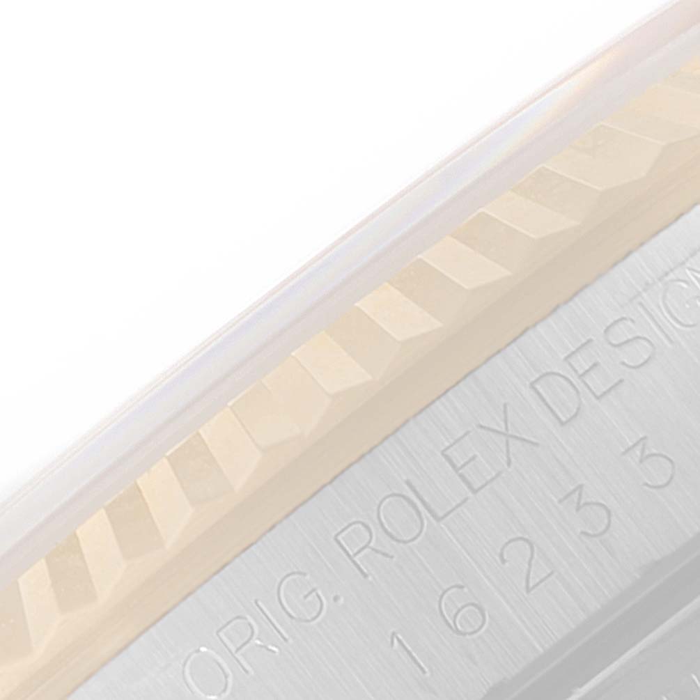 This close-up image shows the fluted bezel and the engraved edge of a Rolex Datejust 16233 Men's Steel and Gold (two tone) Beige Dial 16233 Men's Steel and Gold (two tone) Beige Dial watch case.