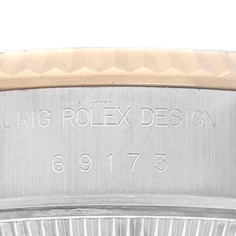 The image shows a close-up of the side of a Rolex Datejust 69173 Women's Steel and Gold (two tone) Grey Dial 69173 Women's Steel and Gold (two tone) Grey Dial model, highlighting the engraved serial number and part of the bezel.