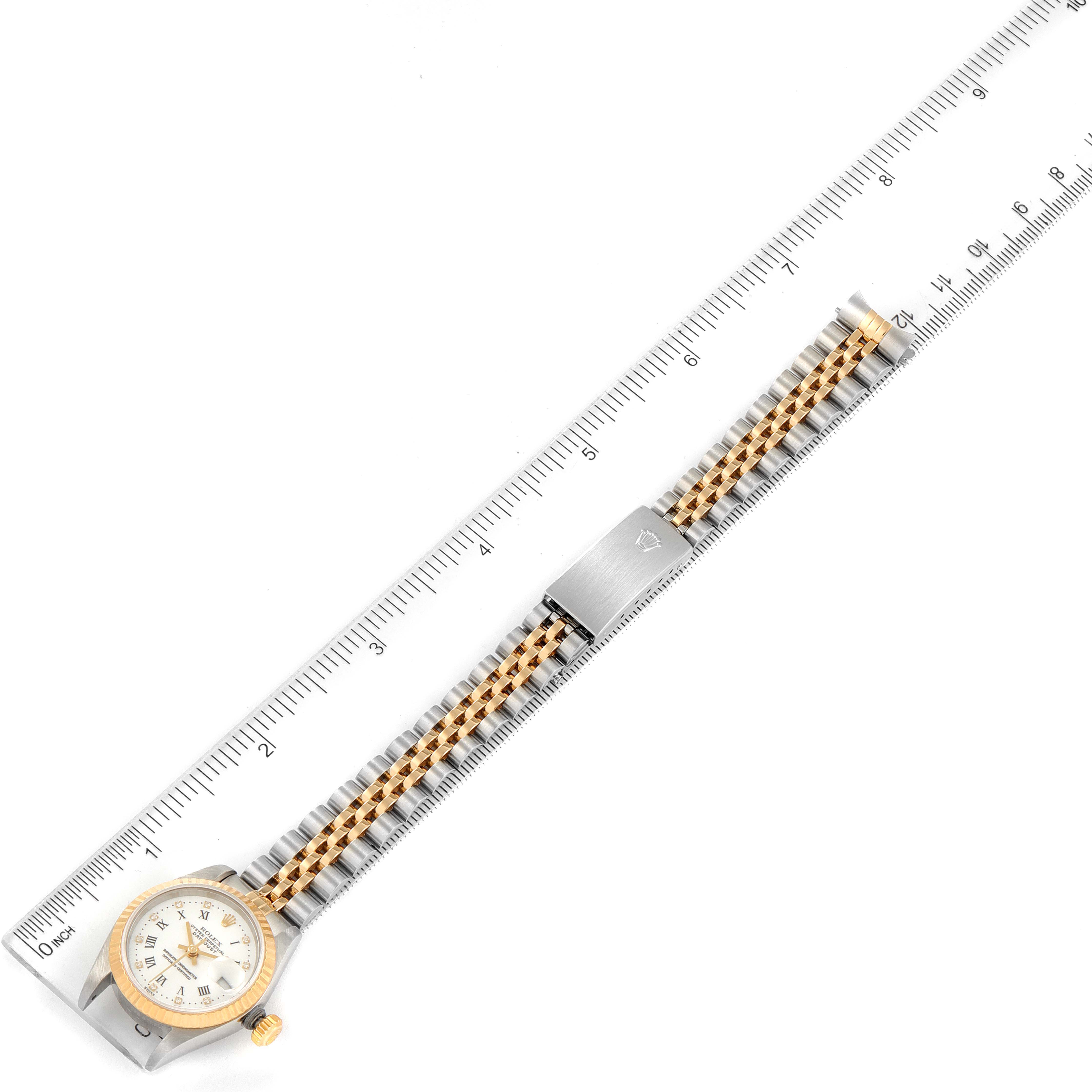 The image shows a top-down view of a Rolex Datejust 79173 Women's Steel and Gold (two tone) White Dial 79173 Women's Steel and Gold (two tone) White Dial watch with a ruler, highlighting the face, bezel, and two-tone bracelet.