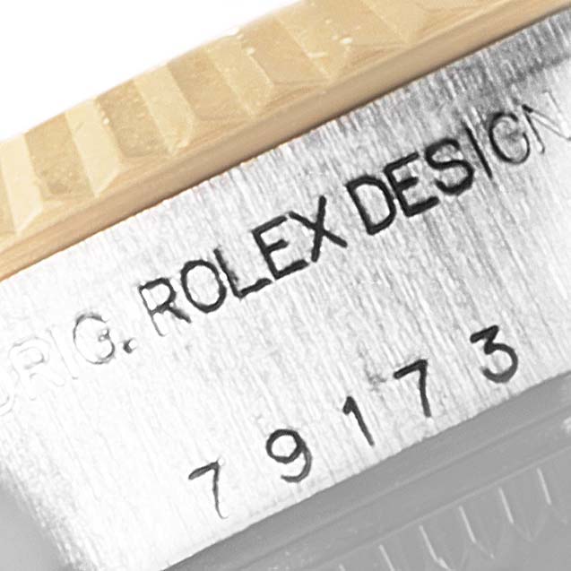 The image shows a macro shot of the case side engraving and part of the bezel on a Rolex Datejust 79173 Women's Steel and Gold (two tone) White Dial 79173 Women's Steel and Gold (two tone) White Dial model.
