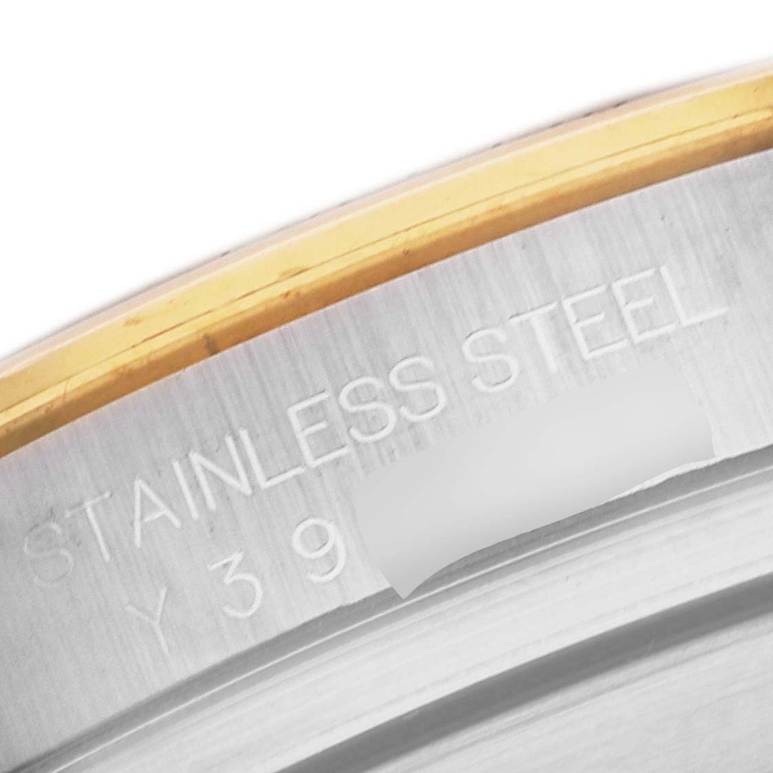 This close-up image of the Rolex Daytona 116523 Men's Steel and Gold (two tone) Champagne Dial 116523 Men's Steel and Gold (two tone) Champagne Dial watch displays the engraved "STAINLESS STEEL" marking on the case.