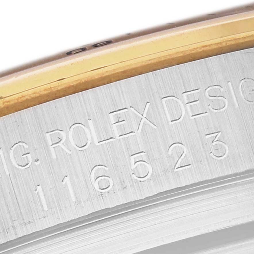 This image shows an angled close-up of the polished bezel and engraved case side of a Rolex Daytona 116523 Men's Steel and Gold (two tone) Champagne Dial 116523 Men's Steel and Gold (two tone) Champagne Dial watch.