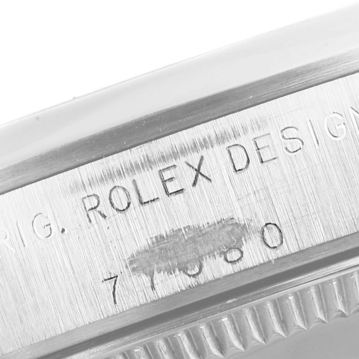 The image shows a close-up view of the engraved serial number on the side of the bezel of a mid-size Rolex watch.