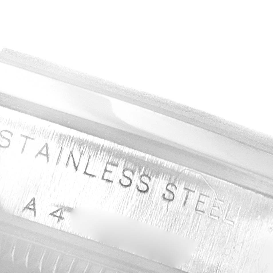 This close-up image shows the engraved "STAINLESS STEEL" text on the side of a Rolex Mid-Size 77080 Women's Stainless Steel Pink Dial 77080 Women's Stainless Steel Pink Dial model watch case.