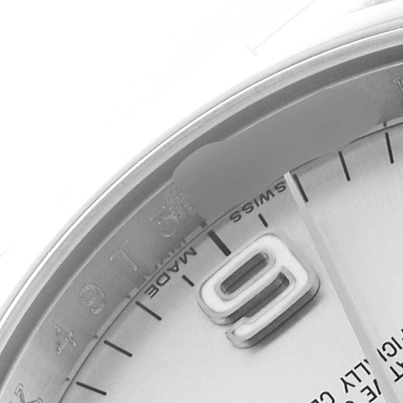 The image shows a close-up of the dial and bezel of a Rolex Oyster Perpetual 116000 Men
s Stainless Steel Silver Dial 116000 Men
s Stainless Steel Silver Dial, highlighting the 9 o
clock marker and "Swiss Made" text.