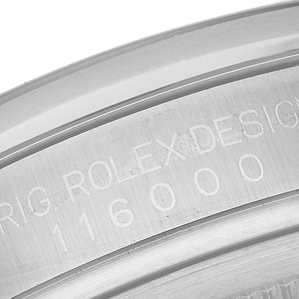This image shows a close-up of the engraved lettering and numbers on the side of a Rolex Oyster Perpetual 116000 Men
s Stainless Steel Silver Dial 116000 Men
s Stainless Steel Silver Dial watch case.