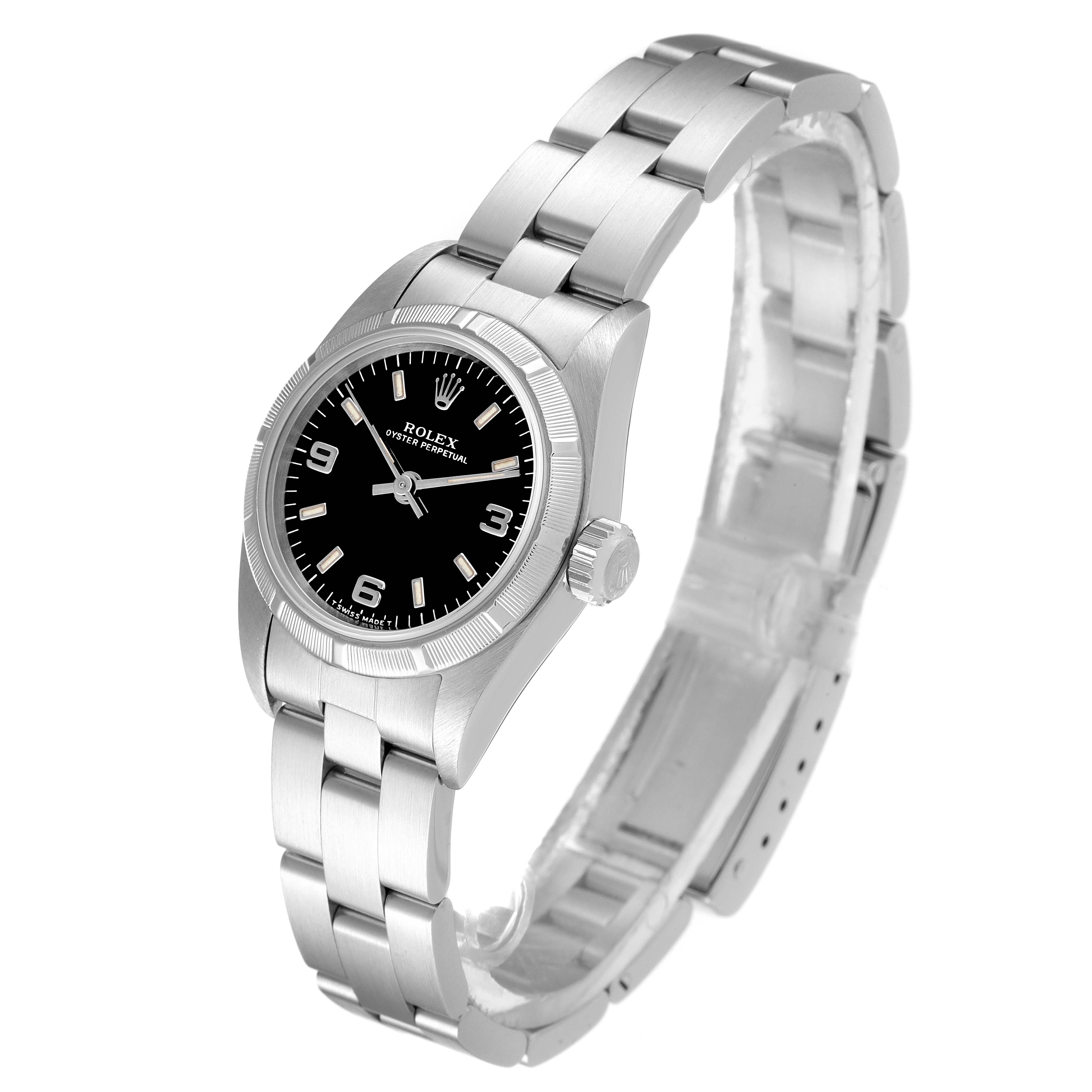 The image shows a Rolex Oyster Perpetual 67230 Women's Stainless Steel Black Dial 67230 Women's Stainless Steel Black Dial watch angled to highlight its black dial, crown, and stainless steel bracelet.