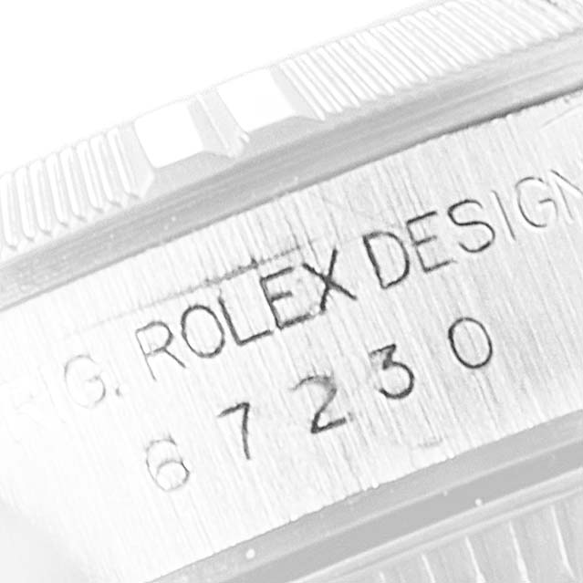 The image shows a close-up angle of the model number and the inscription "ROLEX DESIGN" on the side of a Rolex Oyster Perpetual 67230 Women's Stainless Steel Black Dial 67230 Women's Stainless Steel Black Dial watch.
