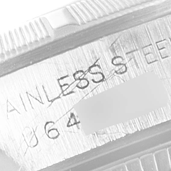 This image shows a close-up of the engraved "Stainless Steel" text and partial serial number on the side casing of a Rolex Oyster Perpetual 67230 Women's Stainless Steel Black Dial 67230 Women's Stainless Steel Black Dial watch.