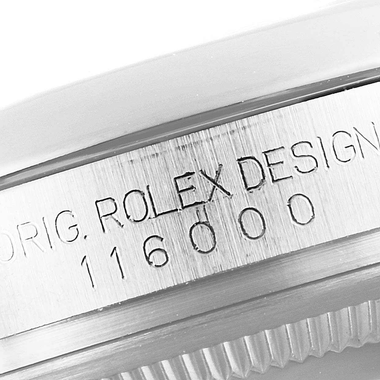 The image shows a close-up of the serial number and engraving on the side of the case of a Rolex Oyster Perpetual 116000 Men's Stainless Steel Blue Dial 116000 Men's Stainless Steel Blue Dial model.