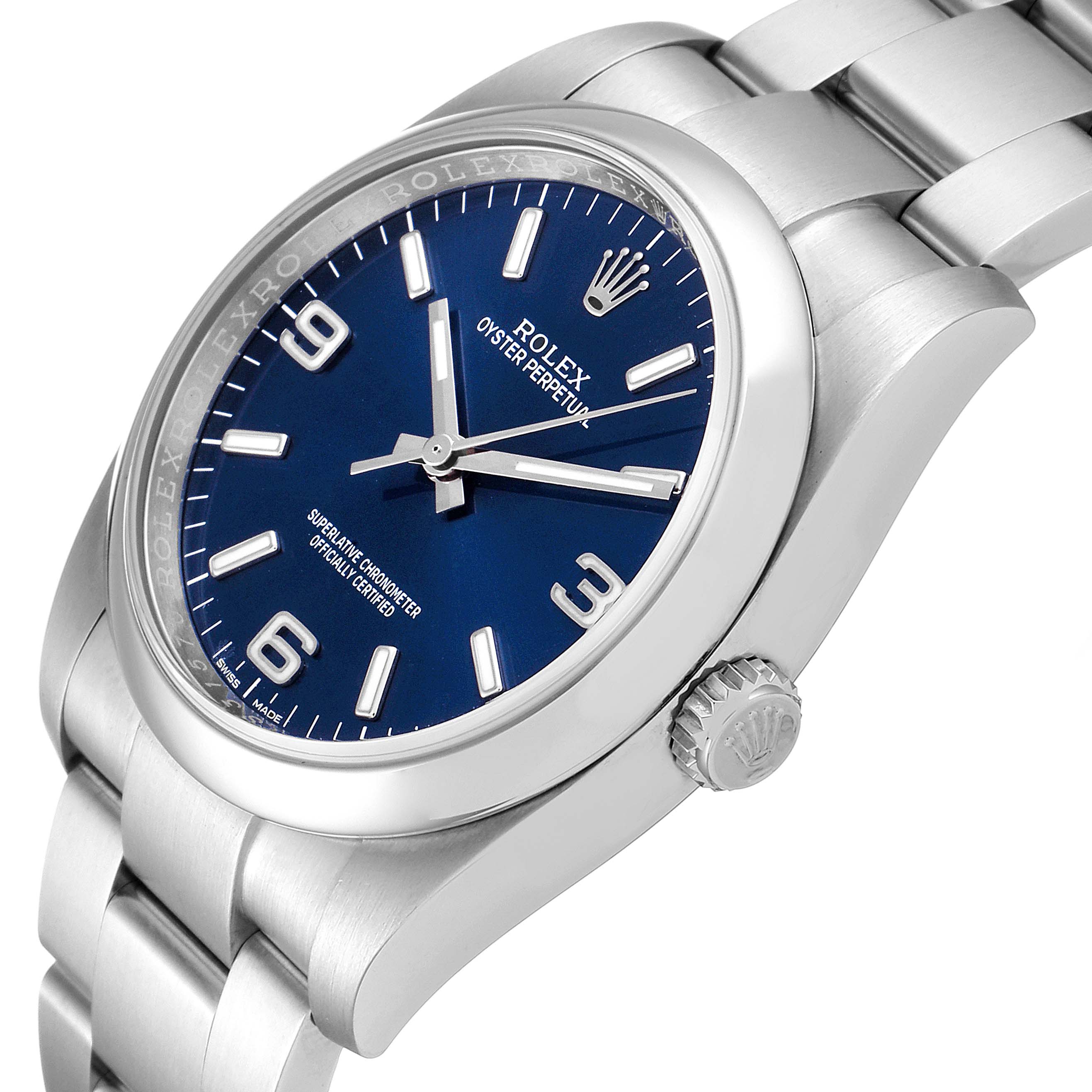 The image shows a side angle of the Rolex Oyster Perpetual 116000 Men's Stainless Steel Blue Dial 116000 Men's Stainless Steel Blue Dial watch, focusing on its crown, bezel, blue dial, and part of the bracelet.