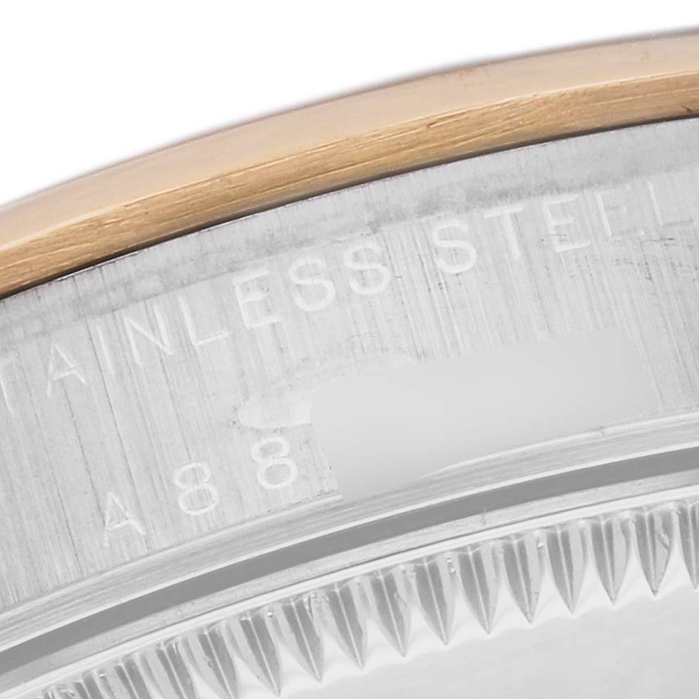 This image shows a close-up of the stainless steel and gold bezel of a Rolex Mid-Size 77483 Women's Steel and Gold (two tone) Grey Dial 77483 Women's Steel and Gold (two tone) Grey Dial watch, highlighting its serial number.