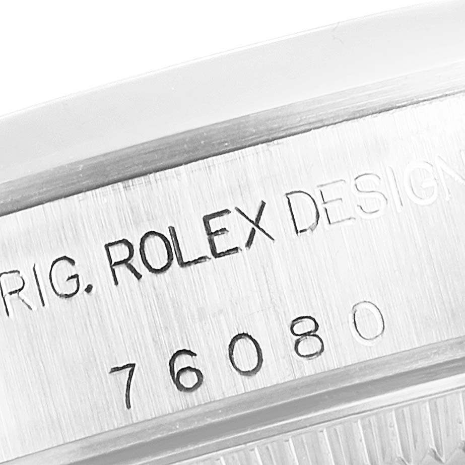 This close-up angle of the Rolex Oyster Perpetual 76080 Women's Stainless Steel Silver Dial 76080 Women's Stainless Steel Silver Dial watch shows part of its engraved case back, including the "Rolex Design" inscription and model number 76080.