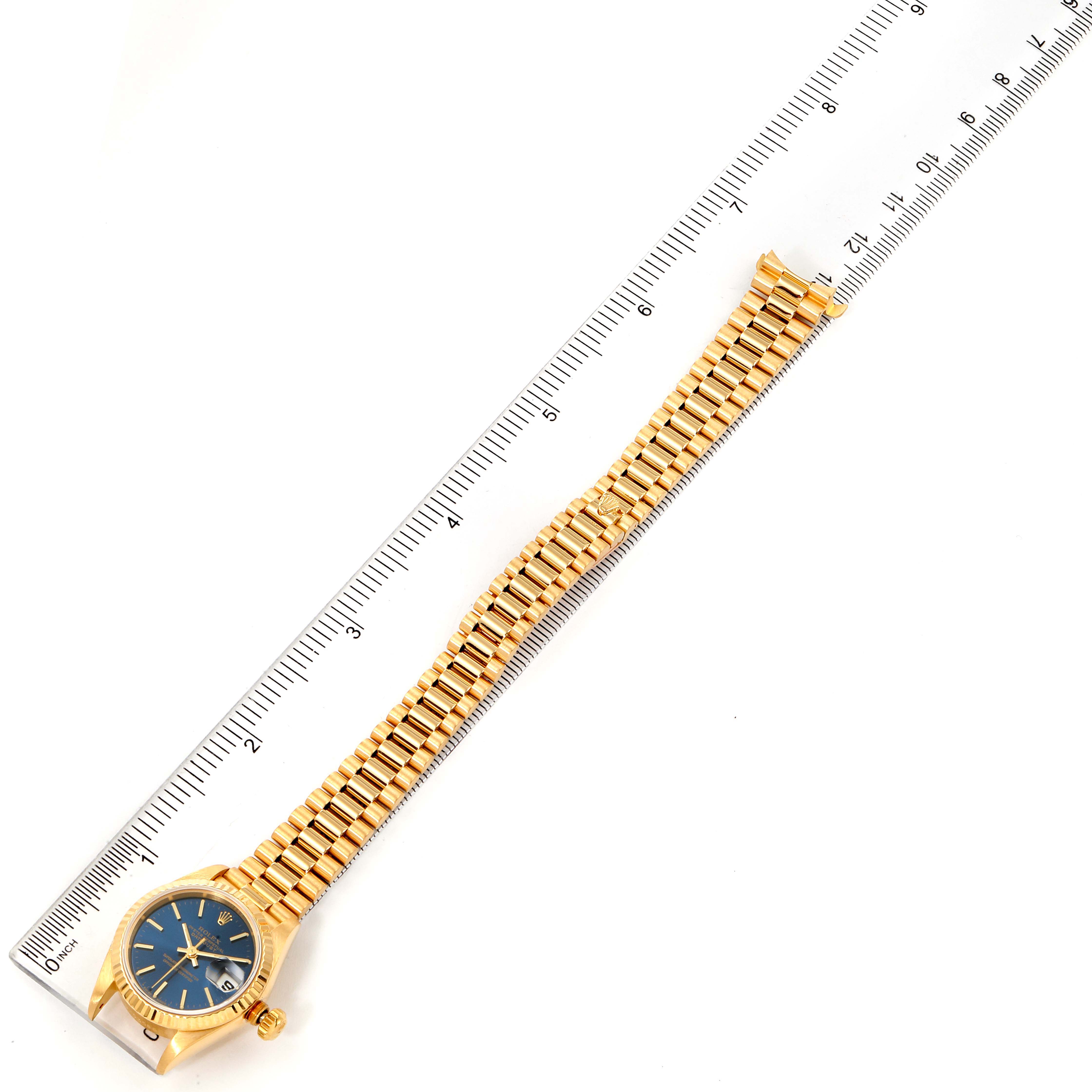 The image shows a Rolex President 69178 Women's Yellow Gold Blue Dial 69178 Women's Yellow Gold Blue Dial model watch laid flat, with a gold bracelet aligned parallel to a ruler for measurement.