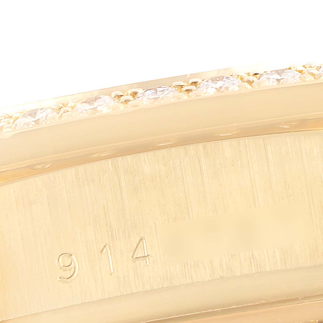 This close-up image shows the side of a Rolex President 18048 Men
s Yellow Gold Champagne Dial 18048 Men
s Yellow Gold Champagne Dial model watch bezel, showcasing part of the serial number and a diamond setting.