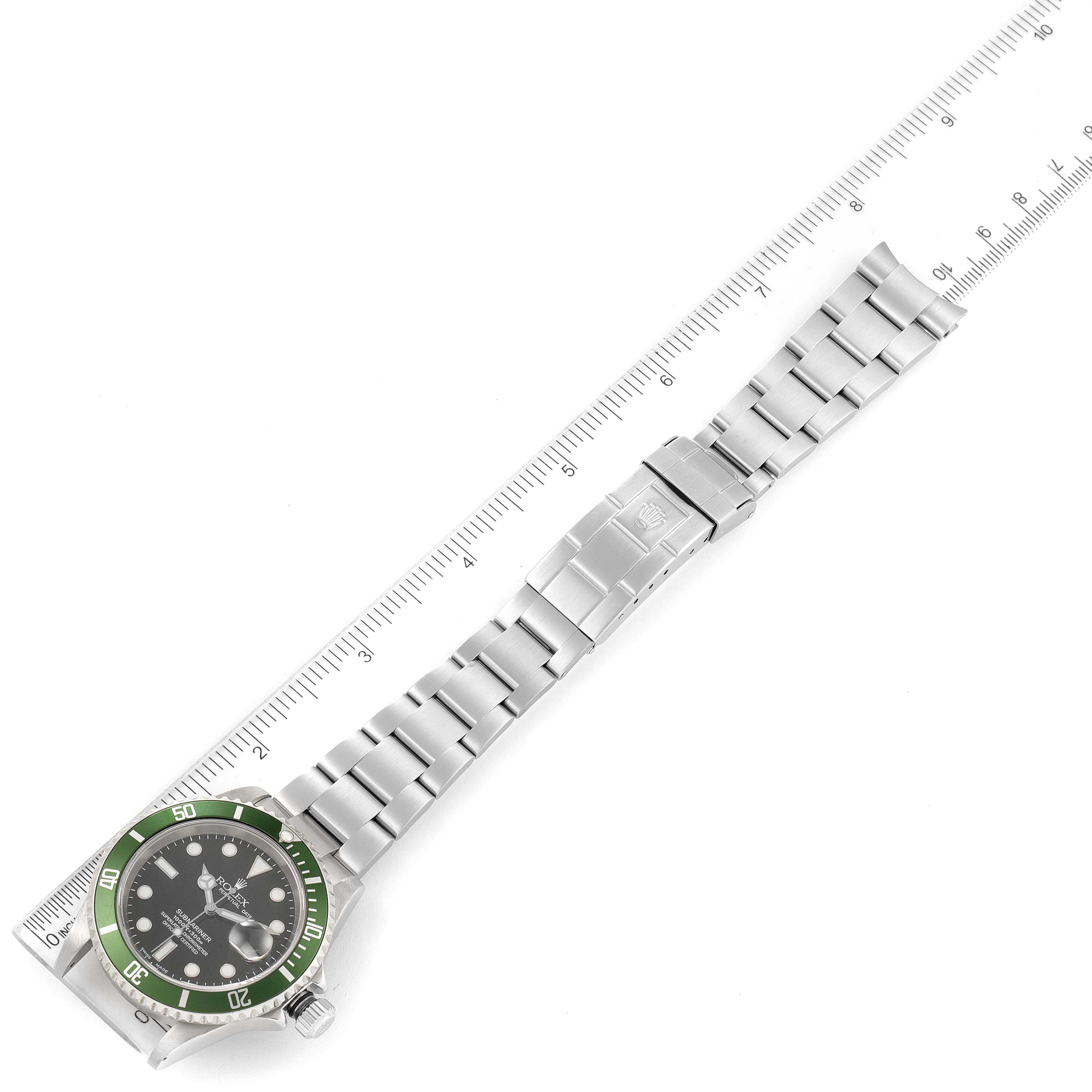 The Rolex Submariner 16610LV Men's Stainless Steel Black Dial watch is shown from a top-down angle with its band extended next to a ruler.