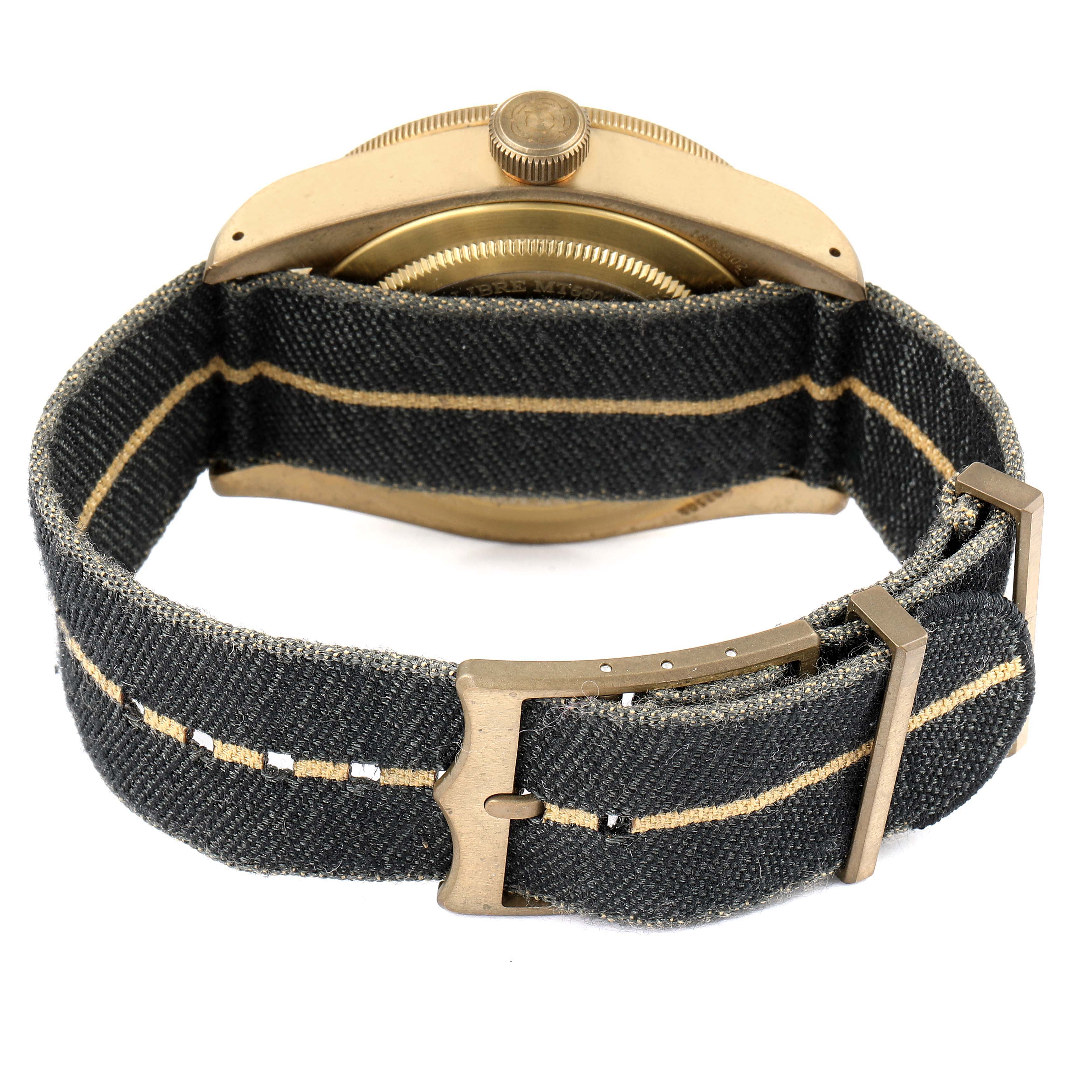 The image shows the back of a Tudor Heritage Black Bay 79250BA Men's Bronze Black Dial 79250BA Men's Bronze Black Dial watch with a fabric strap, buckle, case back, and crown visible.