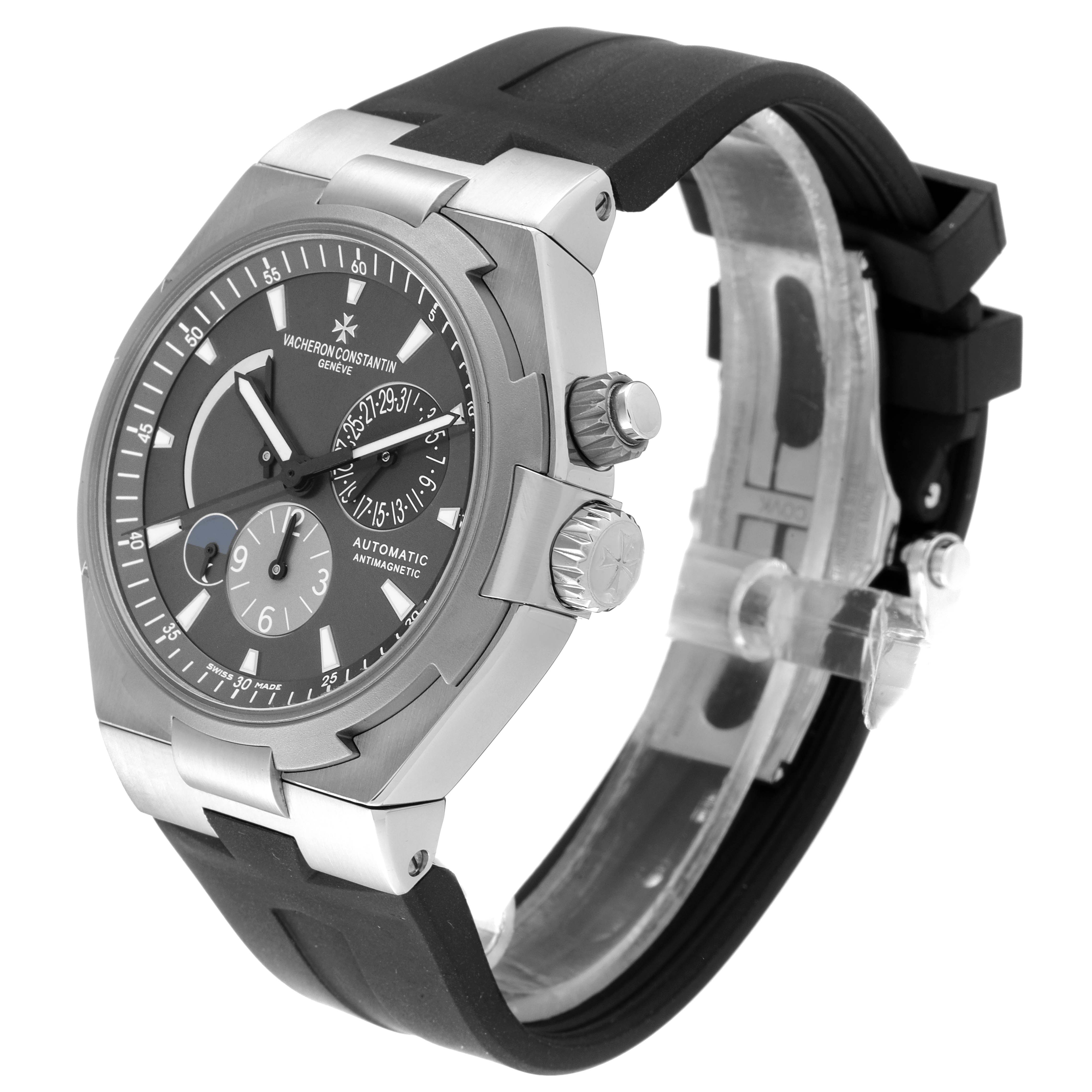 The Vacheron Constantin Overseas 47450/000W-9511 Men's Stainless Steel Grey Dial 47450/000W-9511 Men's Stainless Steel Grey Dial watch is shown at a three-quarter angle, displaying the face, crown, and part of the strap.