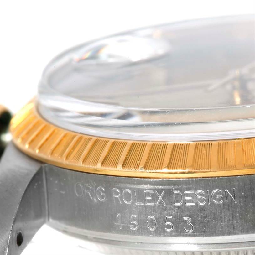 This image shows a side view of the bezel, crystal, and part of the case with engraving on a Rolex Date 15053 Men's Steel and Gold (two tone) Champagne Dial 15053 Men's Steel and Gold (two tone) Champagne Dial model.