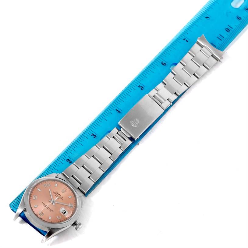 The image shows a Rolex Date 15200 Men's Stainless Steel Pink Dial 15200 Men's Stainless Steel Pink Dial model watch laid flat with a blue ruler, displaying the dial, bracelet, and clasp.