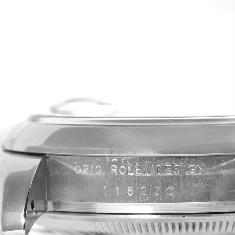 This image shows a close-up of the side of a Rolex Date 115200 Men's Stainless Steel Black Dial 115200 Men's Stainless Steel Black Dial watch, highlighting the engraved model number and "Orig. Rolex Design" text.