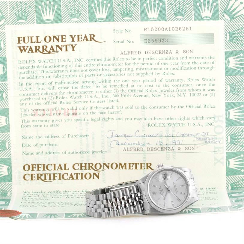 The image shows a Rolex Date 15200 Men's Stainless Steel Silver Dial 15200 Men's Stainless Steel Silver Dial model watch laying flat, in front of a warranty certificate.