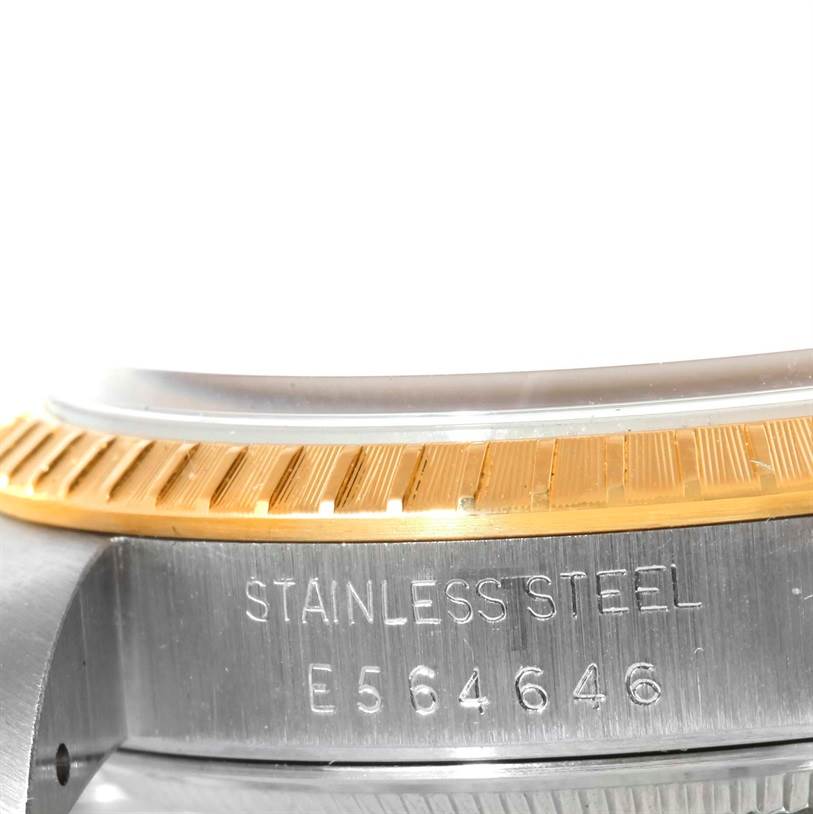 The image shows a close-up of the bezel and case of a Rolex Date 15223 Men's Steel and Gold (two tone) Champagne Dial 15223 Men's Steel and Gold (two tone) Champagne Dial model watch, highlighting the stainless steel and serial number.
