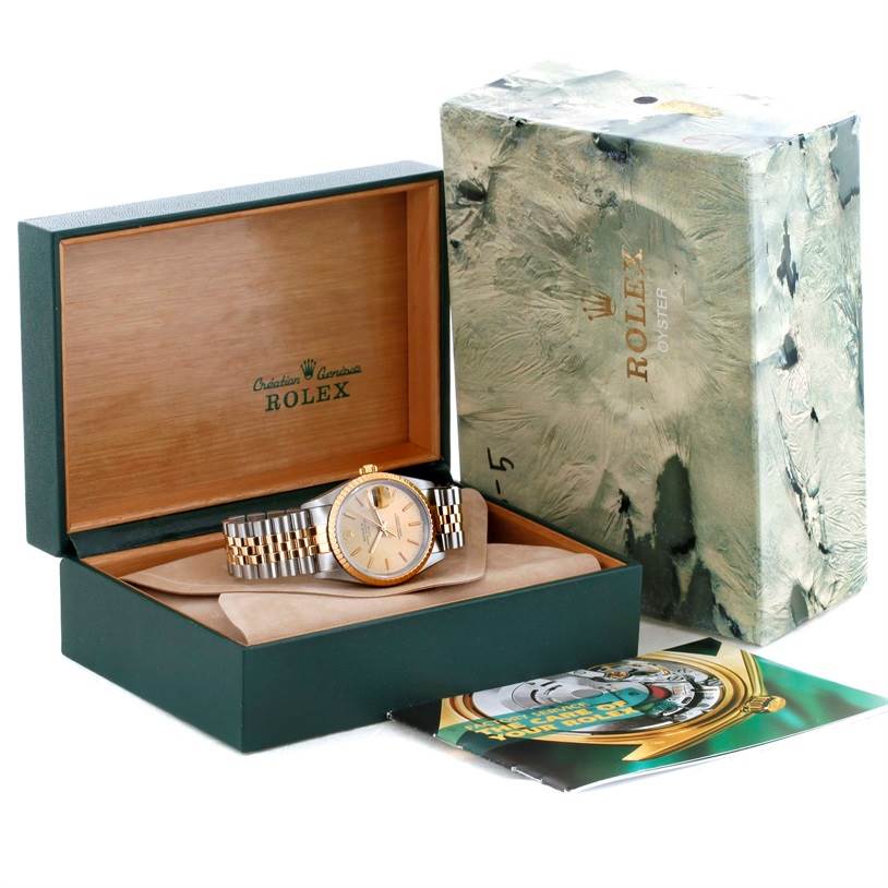 The image displays a Rolex Date 15223 Men's Steel and Gold (two tone) Champagne Dial 15223 Men's Steel and Gold (two tone) Champagne Dial model watch, viewed from the top inside its open box with its outer box and booklet visible.