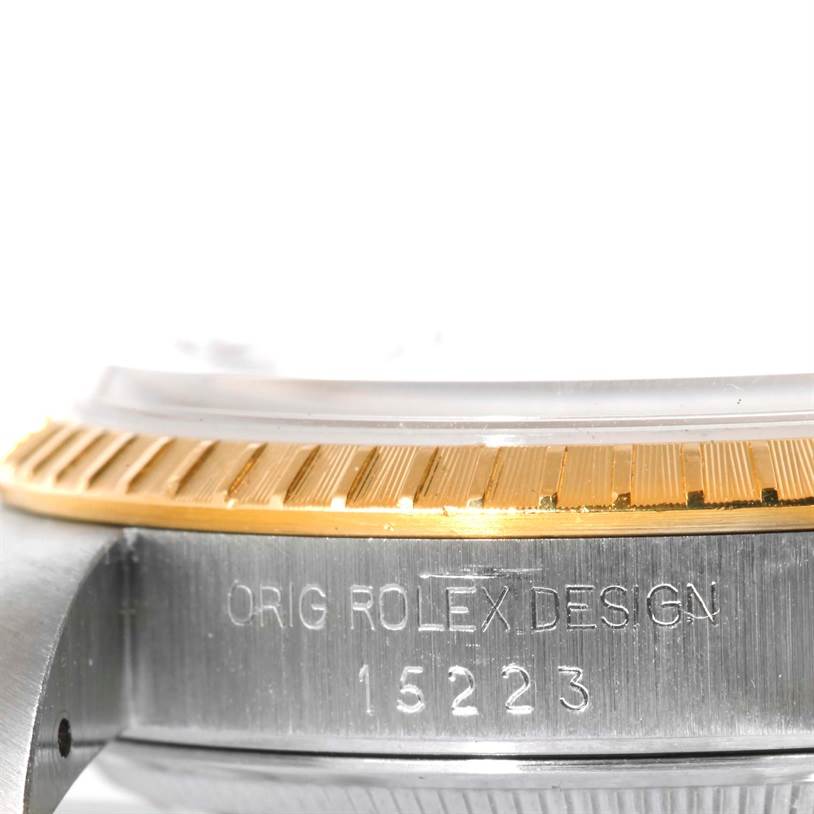 This close-up image shows the side view of a Rolex Date 15223 Men's Steel and Gold (two tone) Champagne Dial 15223 Men's Steel and Gold (two tone) Champagne Dial model watch, highlighting the bezel and serial number.