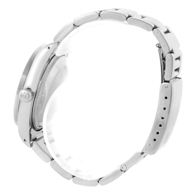 The image shows a Rolex Date 15210 Men's Stainless Steel Silver Dial 15210 Men's Stainless Steel Silver Dial model watch from a side angle displaying the crown and bracelet.