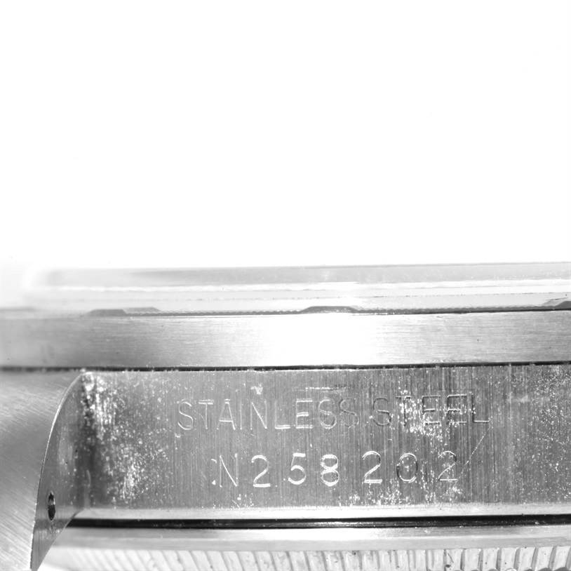 The image shows a close-up side angle of a stainless steel part of a Rolex Date 15210 Men's Stainless Steel Silver Dial 15210 Men's Stainless Steel Silver Dial model watch with the serial number visible.