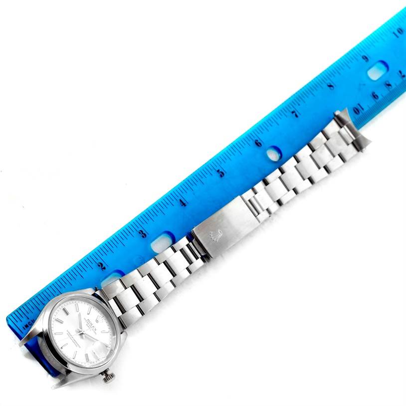 The Rolex Date 15200 Men's Stainless Steel Silver Dial 15200 Men's Stainless Steel Silver Dial model watch is shown from the top-down angle with a blue ruler for scale.