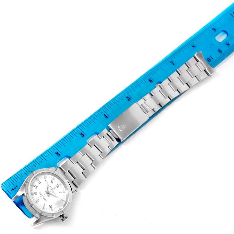 The image shows a Rolex Date 15210 Men's Stainless Steel White Dial 15210 Men's Stainless Steel White Dial model watch laid alongside a blue ruler, displaying its face and bracelet from a top-down angle.