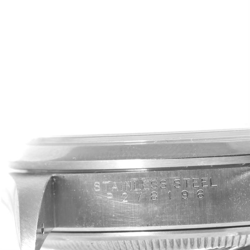 The image shows a close-up of the side of a Rolex Date 15200 Men's Stainless Steel Black Dial 15200 Men's Stainless Steel Black Dial model, highlighting the stainless steel inscription and partial case.