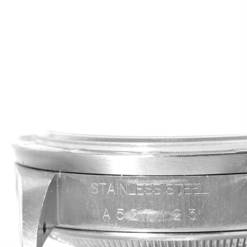 The image shows a close-up, side view of a stainless steel case of the Rolex Date 15210 Men's Stainless Steel Black Dial 15210 Men's Stainless Steel Black Dial model, highlighting the serial number.