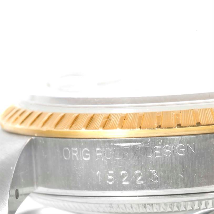 This image shows a side angle of the case of a Rolex Date 15223 Men's Steel and Gold (two tone) Champagne Dial 15223 Men's Steel and Gold (two tone) Champagne Dial watch, highlighting the bezel and case with the engraved model number 15223.