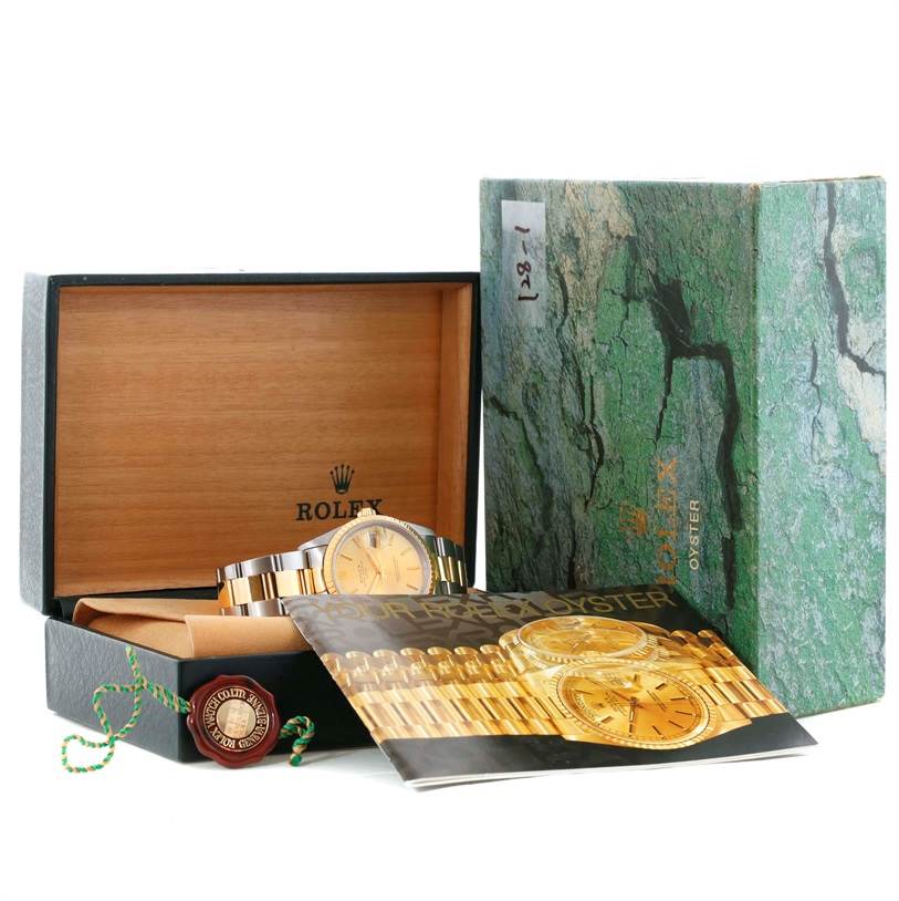 This image shows a Rolex Date 15223 Men's Steel and Gold (two tone) Champagne Dial 15223 Men's Steel and Gold (two tone) Champagne Dial watch in its box with the outer cover, a booklet, and a tag accessory.