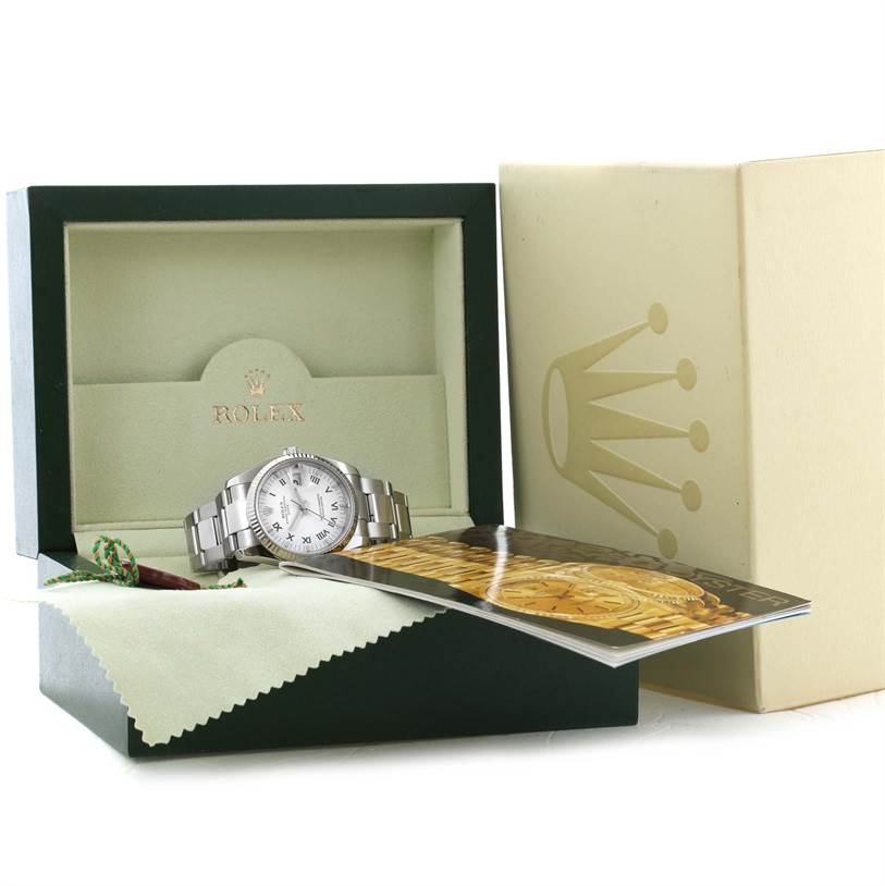 The Rolex Date 115234WRO Men's Stainless Steel White Dial 115234WRO Men's Stainless Steel White Dial watch is shown in its box, along with the manual, tag, and cleaning cloth.