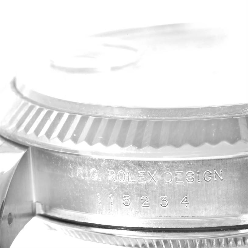 A close-up side angle showing the bezel and the engraved serial number of a Rolex Date 115234WRO Men's Stainless Steel White Dial 115234WRO Men's Stainless Steel White Dial model watch.