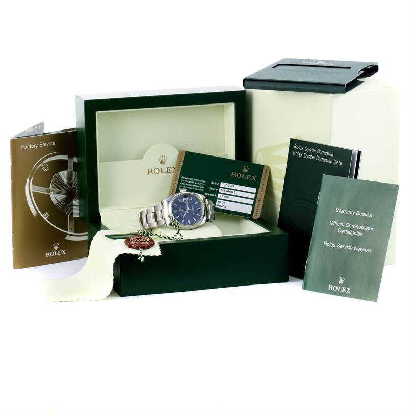 The image shows a Rolex Date 115200 Men's Stainless Steel Blue Dial 115200 Men's Stainless Steel Blue Dial model watch and its accessories, including the box, warranty booklet, and various certification cards.