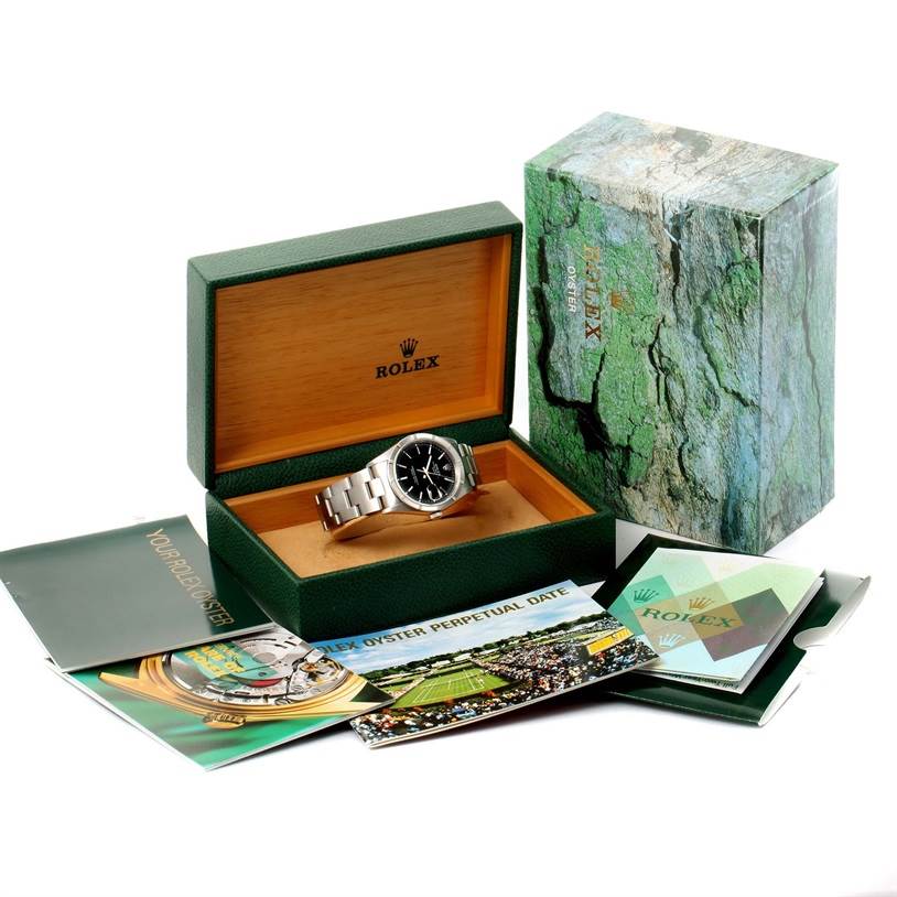 The image shows a Rolex Date 15210 Men's Stainless Steel Black Dial 15210 Men's Stainless Steel Black Dial watch with a black dial in an open box, accompanied by manuals and accessories on the side.