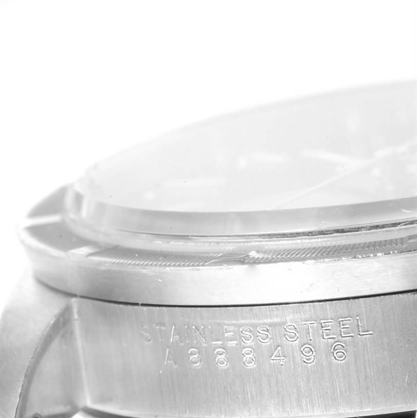 This close-up image of a Rolex Date 15210 Men's Stainless Steel Black Dial 15210 Men's Stainless Steel Black Dial model watch shows the side of the case with stainless steel engraving and part of the bezel and crystal.