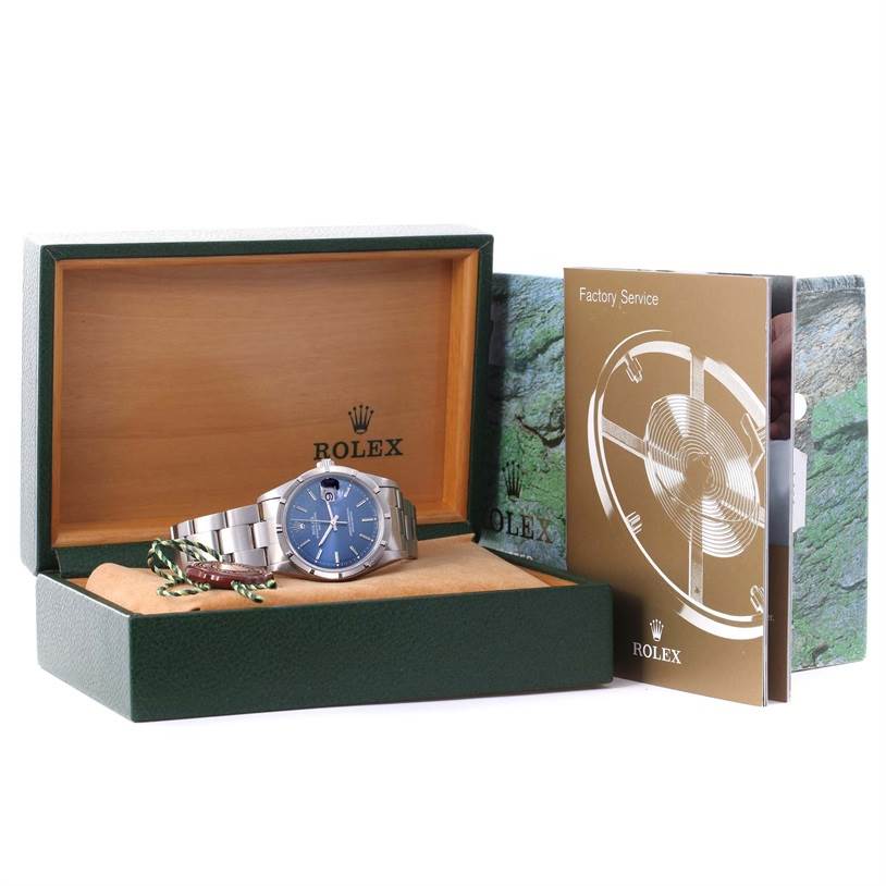 The image shows a Rolex Date 15210 Men's Stainless Steel Blue Dial 15210 Men's Stainless Steel Blue Dial model watch inside its open box, accompanied by a factory service booklet.
