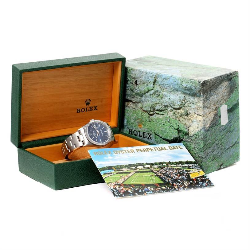 This image shows a Rolex Date 15210 Men's Stainless Steel Blue Dial 15210 Men's Stainless Steel Blue Dial model watch inside its open green and wooden box, along with its outer packaging and booklet.