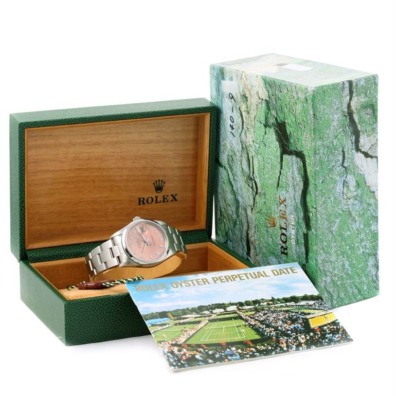 The Rolex Date 15200 Men's Stainless Steel Pink Dial 15200 Men's Stainless Steel Pink Dial watch is shown in an open green and wooden case, with pamphlets and the outer box included.
