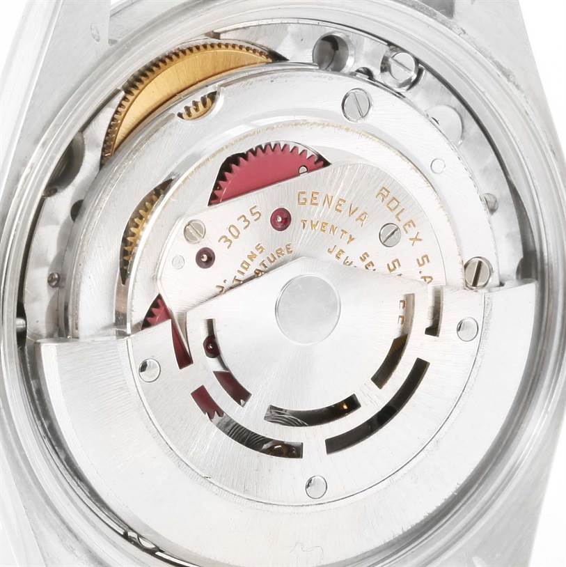 The image shows the internal mechanism of a Rolex Date 15000 Men's Stainless Steel White Dial 15000 Men's Stainless Steel White Dial model watch, focusing on the movement and gears.