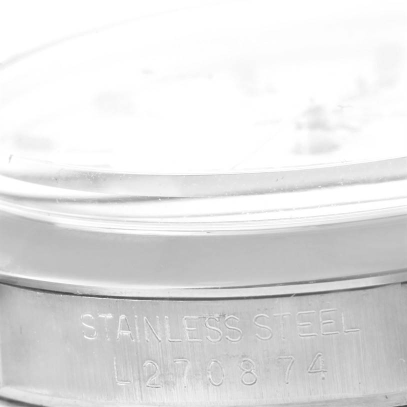 This close-up image of the Rolex Date 15000 Men's Stainless Steel White Dial 15000 Men's Stainless Steel White Dial model watch shows the side of the case with "STAINLESS STEEL" engraving.