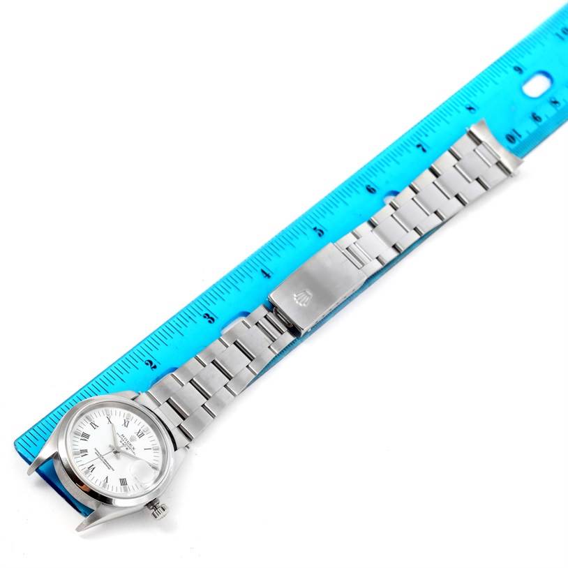 The Rolex Date 15200 Men's Stainless Steel  15200 Men's Stainless Steel  watch is shown from a top-down angle, displaying its face, bracelet, and clasp alongside a ruler for scale.