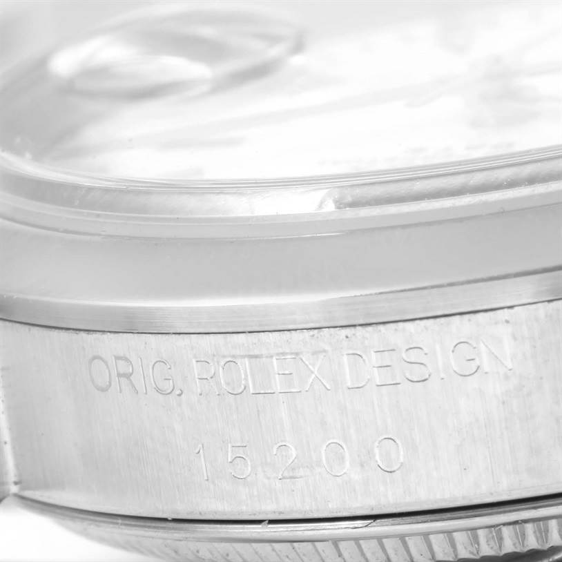 The image shows a close-up of the side of a Rolex Date 15200 Men's Stainless Steel  15200 Men's Stainless Steel  model watch with part of the bezel and crystal visible.